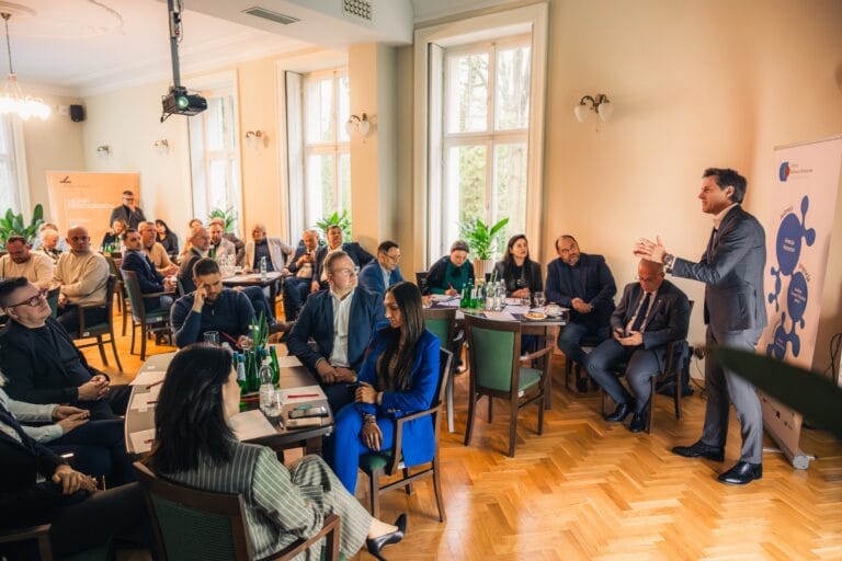 Uczestnicy spotkania biznesowego w jasnej sali